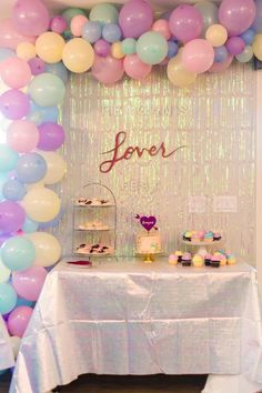 a table topped with lots of balloons and cupcakes