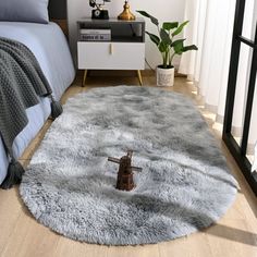 a bedroom with a bed, nightstand and rug in the shape of a cross on the floor