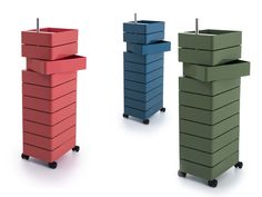 three different colored boxes with handles on wheels