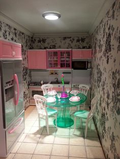 a kitchen with pink cabinets and green table in the center, white chairs around it