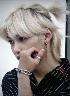 a woman with blonde hair and piercings on her ear is looking at the camera