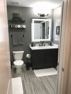 a bathroom with a toilet, sink and mirror in the middle of it's room