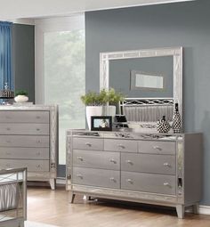 a silver dresser and mirror in a room