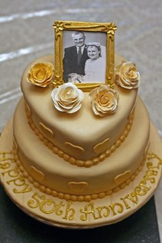 there is a cake that has been decorated with flowers and a picture frame on top