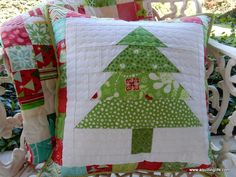 a quilted christmas tree pillow sitting on top of a chair