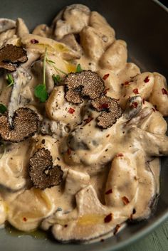 a bowl filled with pasta and mushrooms covered in sauce