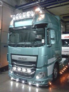 a large semi truck parked in a garage with lights on it's headlamps