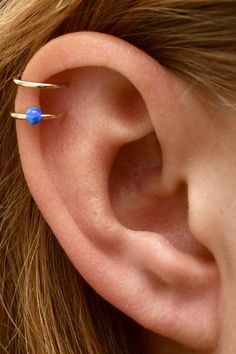 This is a beautifully minimalist ear cuff that showcases a dainty blue or white opal. It is a non pierced cuff that hugs the top of the ear to add the perfect little touch to any style or outfit. Available in: Sterling Silver with White Opal 14K Gold Filled with White Opal Sterling Silver with Blue Opal 14K Gold Filled with White Opal .This piece will arrive in a pretty Gift Box and include simple fitting instructions. Perfect for gift giving Dainty Adjustable Ear Cuff For Pierced Ears, Adjustable Hypoallergenic Ear Cuff As Gift, Minimalist Internally Threaded Ear Cuff As Gift, Adjustable Nickel-free Ear Climbers As Gift, Minimalist Pierced Adjustable Ear Cuff, Minimalist Adjustable Pierced Ear Cuff, Dainty Adjustable Hypoallergenic Ear Cuff, Minimalist Ear Cuff For Wedding, Tiny Adjustable Ear Cuff As Gift