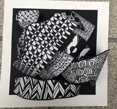 black and white paper cut into shapes on top of a piece of paper