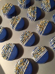 blue and gold decorated cookies sitting on top of a cookie sheet