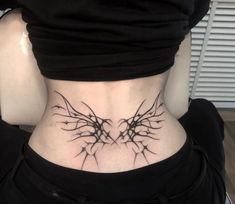 the back of a woman's neck with branches tattoo on her lower body and chest