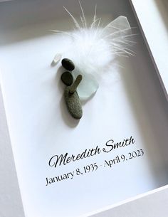 a white box with some rocks and a feather on the top that says, meradite smithe january 8, 1953 apr 9 23