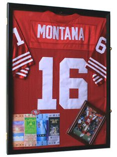 a football jersey is hanging on the wall with other items around it, including an autographed photo