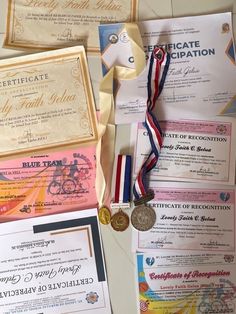 several awards and ribbons are laid out on a table with some paper attached to them