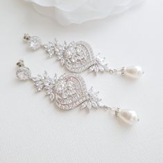 the bride's earrings are adorned with crystal and pearls