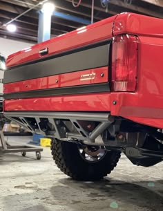 the rear end of a red truck parked in a garage