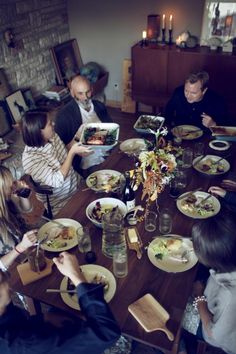 a group of people sitting around a table eating food