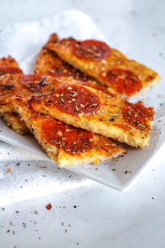 three slices of pizza sitting on top of a white plate