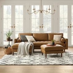 a living room scene with focus on the couch and chair, coffee table and ottoman