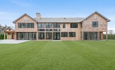 a large house sitting on top of a lush green field