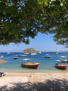 several boats are docked on the beach in clear blue water