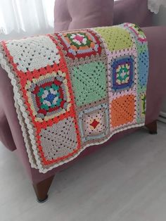 a crocheted blanket is sitting on a couch