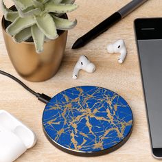 a cell phone and ear buds sitting next to each other on a wooden table near a plant