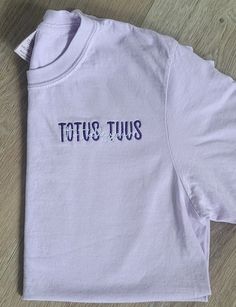 "This Listing is for our Totus Tuus, Totally Yours, embroidered Catholic t-shirt. It is a beautiful Marian t-shirt; in Latin, the phrase, \"Totus Tuus,\" means \"totally yours\", a motto from JPII, who had a great devotion to our blessed Mother.  When placing your order, in the personalization box, please include the following information: 1.) Two Thread colors (one for \"TOTUS TUUS\" and one for \"Totally Yours\" If no thread color is entered, we will automatically use colors as shown in the sa Basic Cotton Tops With Custom Embroidery And Relaxed Fit, Basic Relaxed Fit Top With Custom Embroidery, Casual Short Sleeve Shirt With Letter Embroidery, Purple Cotton Tops With Embroidered Text, Pocket Oratory, Catholic Tshirt, Catholic Fashion, Catholic Clothing, Catholic Shirt