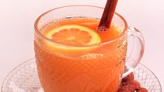 a glass mug filled with orange juice and garnished with an orange slice