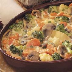 a casserole dish with broccoli, carrots and mushrooms