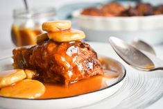 a white plate topped with food covered in sauce