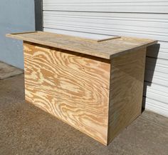 a large wooden box sitting in front of a garage door