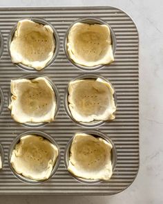 six muffins in a pan on top of a counter