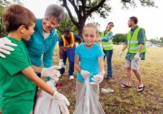 group of people standing around each other with garbage bags