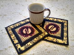 two coasters with the letter s on them and a coffee cup sitting on top