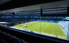 an empty stadium filled with lots of seats and people standing on the sidelines looking out at the field