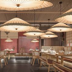 the interior of a restaurant with wooden tables and umbrellas hanging from the ceiling above