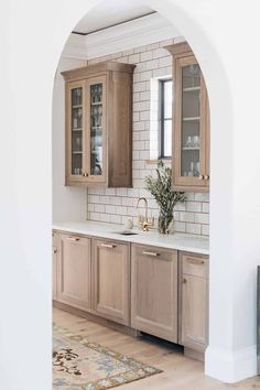 a kitchen with wooden cabinets and white walls