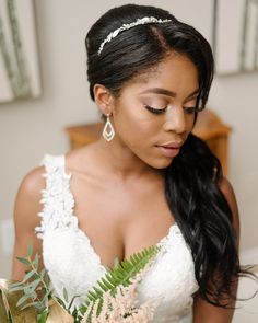 a woman in a wedding dress is holding a bouquet and looking down at her face