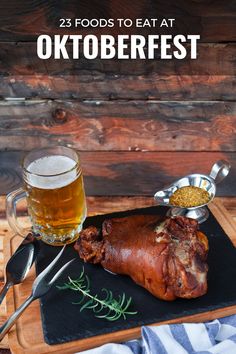 an oktoberfest meal on a cutting board with a mug of beer and spoons