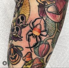 a close up of a person's arm with a spider on it and skulls