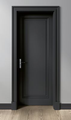 an empty room with a black door and wood flooring on one side, there is a gray wall and wooden floors on the other side