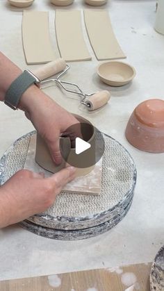 a person is making pottery on a table