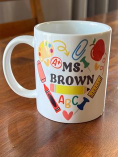 a white coffee mug with the words ms brown on it and school related stickers