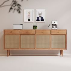 a sideboard with two pictures on the wall