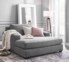 a living room with a gray couch and pink pillows