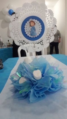 there is a blue and white centerpiece on top of a table with doily