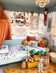 a child's bedroom decorated in blue, orange and white with pictures on the wall