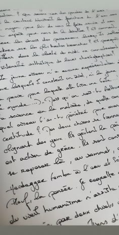 a close up of handwriting on a piece of paper with an ink pen in it