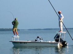 two men fishing on a small boat in the water